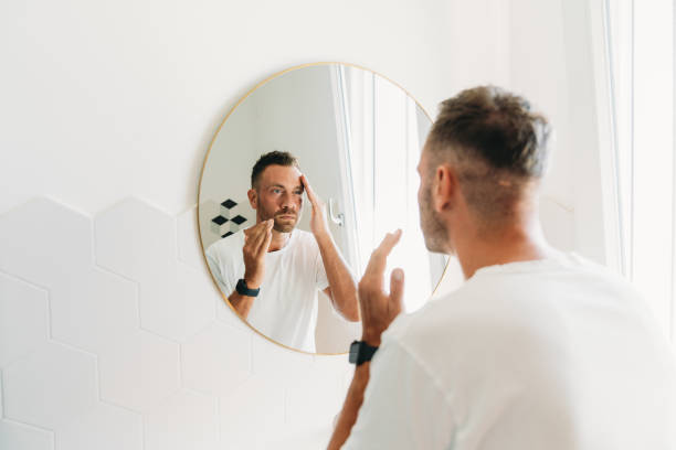 istock A millennial man is using a face cream in the bathroom 1470998232