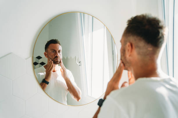 istock A millennial man is using a face cream in the bathroom 1470998233