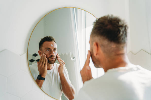 istock A millennial man is using a face cream in the bathroom 1470998239