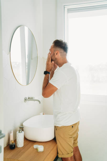 istock A millennial man is using a face cream in the bathroom 1470998240