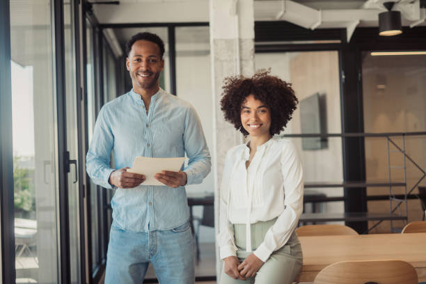 Man and woman standing side by side in the office stock photo