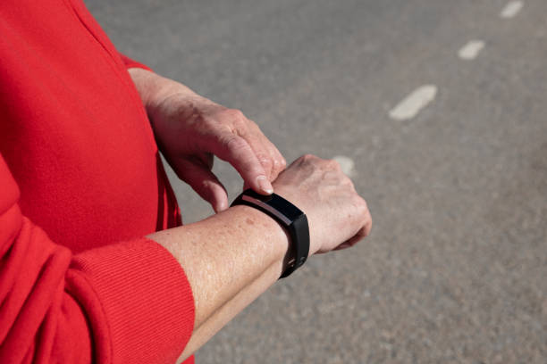 istock Elderly female hands in red sportswear checking time, text message or pulse using digital smartwatch against background of road. Concept of modern technologies and healthy lifestyle 1470998734