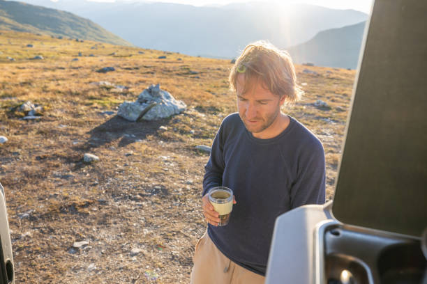 istock Man relaxing with a hot beverage, van life concept 1471000175