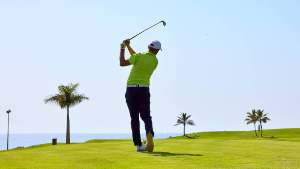 golfeur sur un terrain de golf, prêt à prendre le départ. golfeur avec club de golf frappant la balle pour le coup parfait. - golf playing men ball photos et images de collection