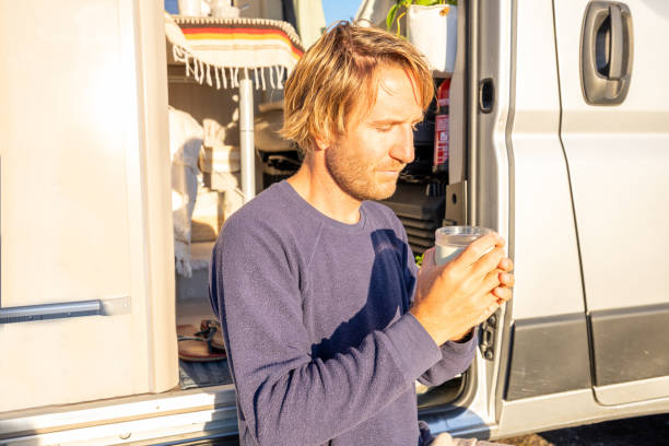 istock Man using solar panels to get power for his van, the van life concept, self sufficiency with renewable energy 1471000783