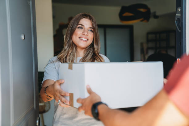 istock Delivery man is giving a box to a woman 1471001934