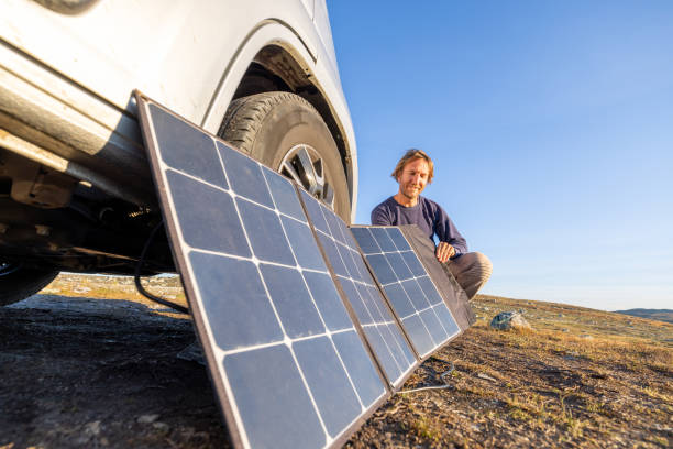istock Man using solar panels to get power for his van, the van life concept, self sufficiency with renewable energy 1471001972