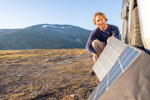 istock Man using solar panels to get power for his van, the van life concept, self sufficiency with renewable energy 1471003209