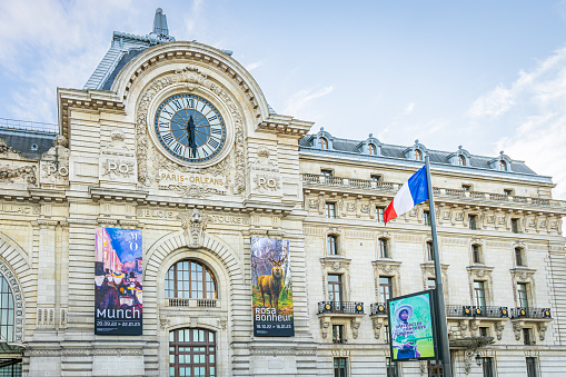 Munch and Rosa Bonheur exhibitions posters and facade of the Orsay museum with view on the giant clock in Paris, France