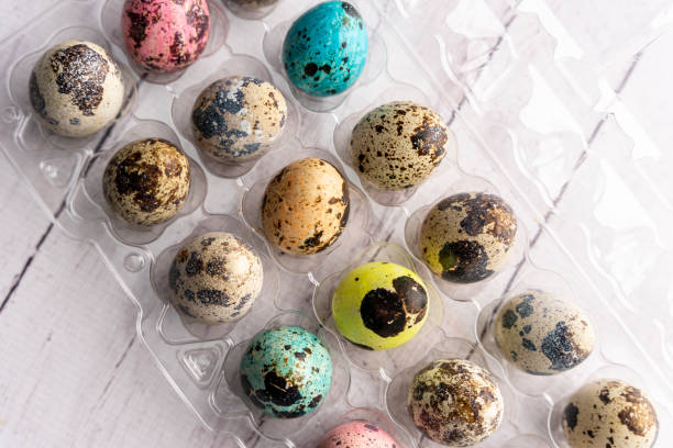 colorful Easter eggs in a container on a light background