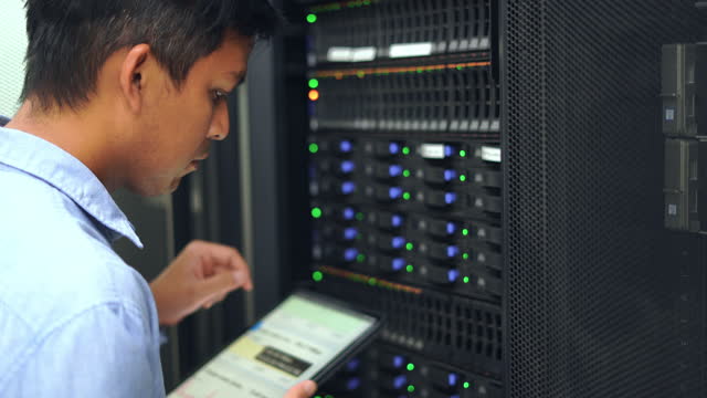 System administrator working with tablet in data center.