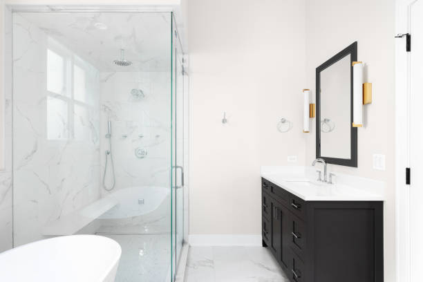 istock A bathroom with a grey cabinet, gold sconces, and marble shower. 1471010729