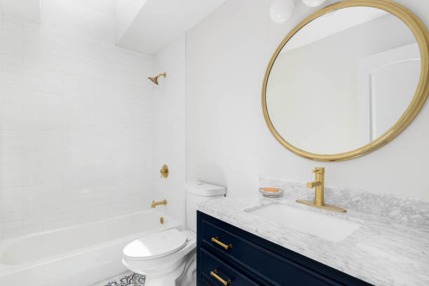 istock A bathroom with a blue cabinet, gold mirror, and tiled shower. 1471010829