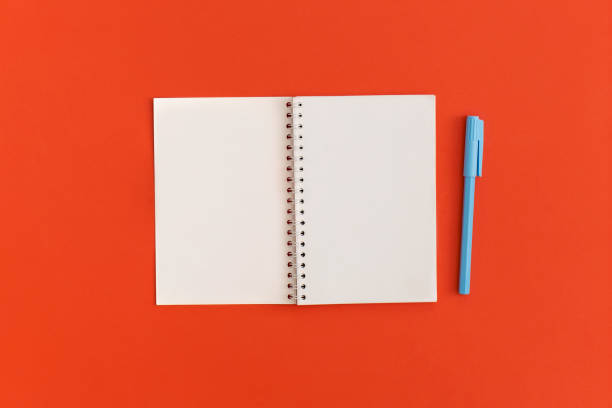 istock Red alarm clock and notebooks with space for text on red background 1471011950