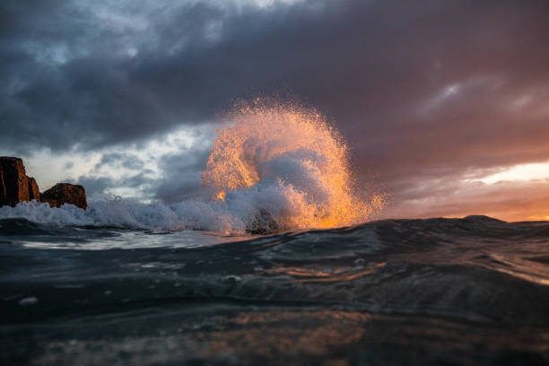 Powerful ocean waves erupting in early morning golden light with dramatic sky. Shot on the south east coast of Australia.