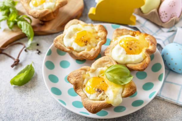 istock Easter breakfast idea. Scrambled eggs in puff pastry with cheese and bacon on a stone background. 1471015242