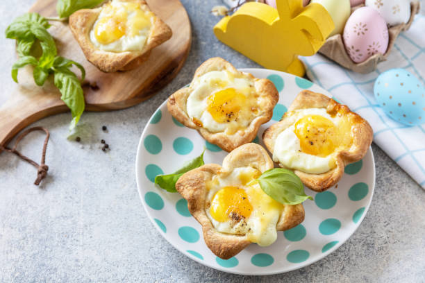 istock Easter breakfast idea. Scrambled eggs in puff pastry with cheese and bacon on a stone background. Copy space. 1471015243