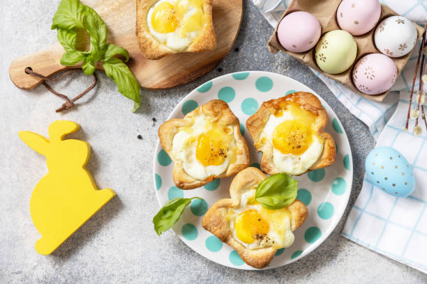 Easter breakfast idea. Scrambled eggs in puff pastry with cheese and bacon on a stone background. View from above.