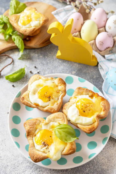 istock Easter breakfast idea. Scrambled eggs in puff pastry with cheese and bacon on a stone background. 1471015250