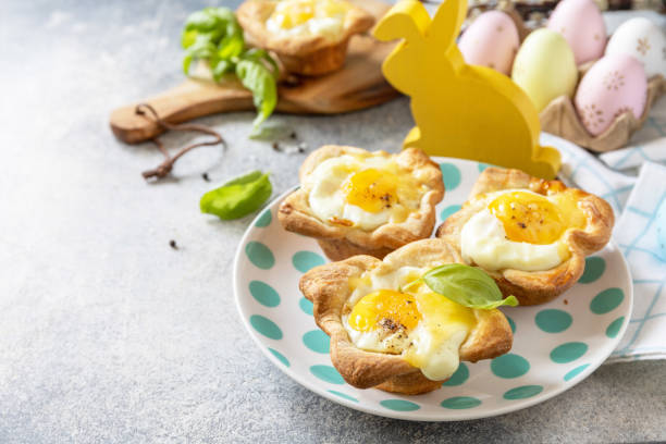 istock Easter breakfast idea. Scrambled eggs in puff pastry with cheese and bacon on a stone background. Copy space. 1471015252