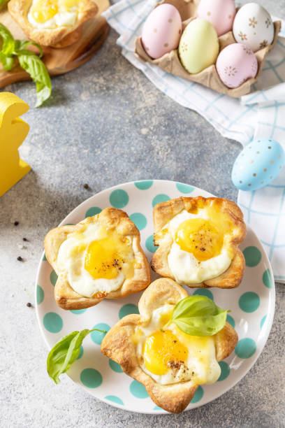 istock Easter breakfast idea. Scrambled eggs in puff pastry with cheese and bacon on a stone background. Copy space. 1471015258