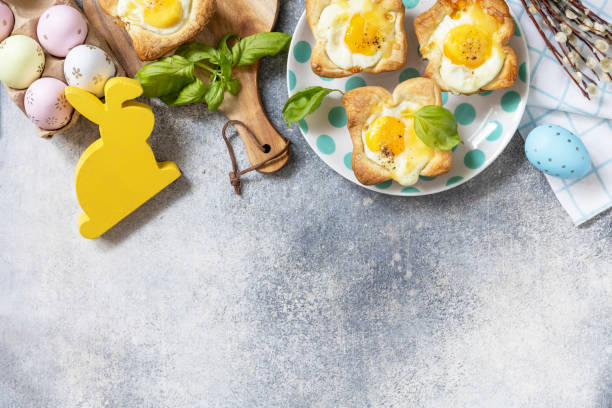 istock Easter breakfast idea. Scrambled eggs in puff pastry with cheese and bacon on a stone background. View from above. Copy space. 1471015260