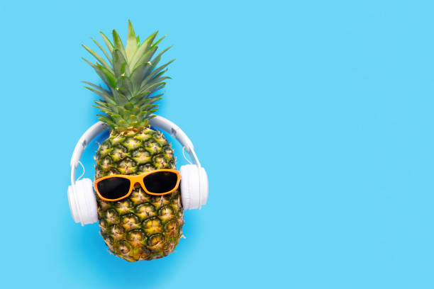 istock Ripe pineapple with sunglasses and headphones on blue background 1471022921