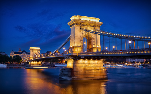 Budapest, Hungary. Chain bridge on Danube river in Budapest city with lanterns for nighttime backlighting and blue sky. Hour evening time