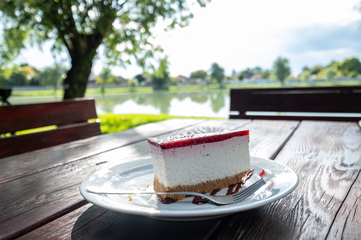 Cake on the table, which is outside by the lake.