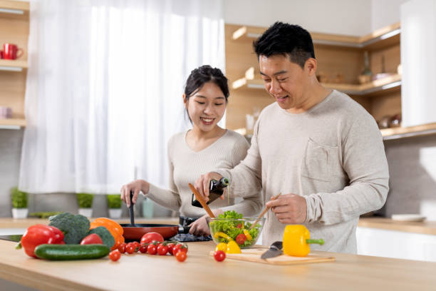 istock Cheerful korean husband and wife making vegetable salad 1471032176