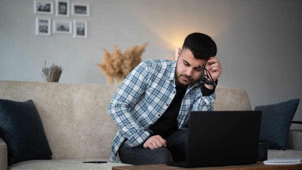 istock Young man looks tired while working at home 1471032333