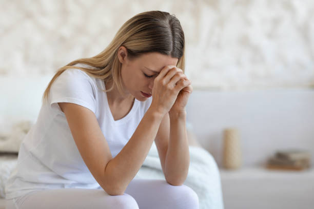 istock Upset blonde lady sitting on bed at home, crying 1471032613