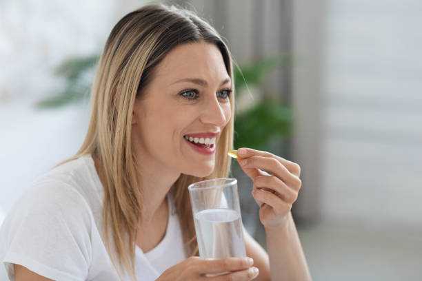 istock Attractive millennial woman taking medicine and looking at copy space 1471032632
