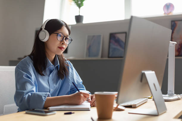 istock Asian Businesswoman Working On Computer And Taking Notes In Office 1471033921