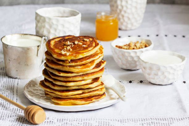 istock Apple pancakes served with honey, sour cream, nuts, tea and coffee. 1471034173