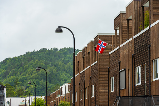 Lindesnes, Norway - August 07 2022: Norwegian flag hanging from the terrace of an apartment.