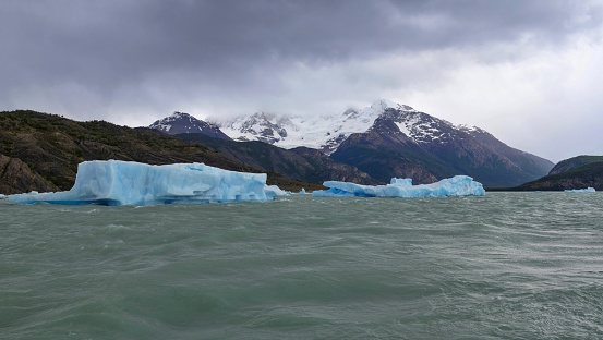Punta Bandera, Argentina, November 2, 2019: Floes of ice float on the surface of the Lake Argentino (Lago Argentino). It is the biggest freshwater lake in Argentina, with a surface area of 1,415 km2 and a maximum depth of 500 m. The Lake is situated in Los Glaciares National Park which was declared a World Heritage Site by UNESCO in 1981.