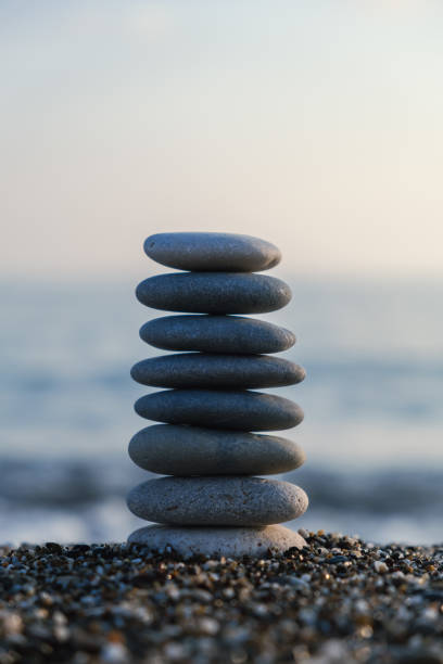 istock Vertical İmage of balanced pebble pyramid silhouette on the beach 1471039730