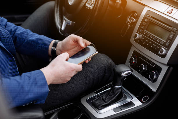 businessman in suit working with project statistics, graph and diagram on phone screen, entrepreneur accountant analysing financial data while sitting in modern car. Male going to workplace by car. hombre de negocios en traje que trabaja con estadísticas de proyectos, gráfico y diagrama en la pantalla del teléfono, contador empresarial que analiza datos financieros mientras está sentado en un automóvil moderno. hombre yendo al lugar de trabajo e
