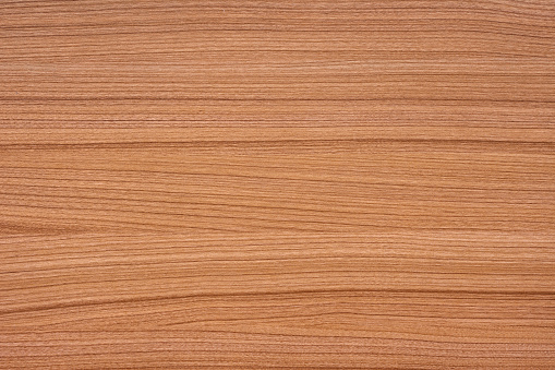 Fine natural wood texture. Top view of reddish brown wooden table. The board have a strong clear texture of wood without damages. A wood grain pattern featuring even grains of wood running horizontally across the image.