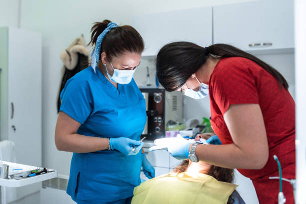 istock Dentist appointment at a dental clinic, placing braces locks on the teeth and pulling the archwire to fix it 1471048404