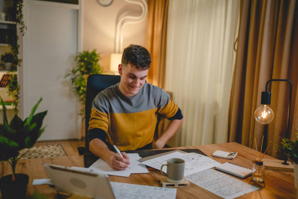 istock Young caucasian man teenager student study at home at the table night 1471054077