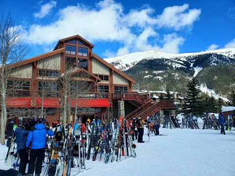 Copper Mountain, Colorado, USA- March 2, 2023: People and skis outside the East Village base area and lodge, Copper Mountain ski resort, Colorado.