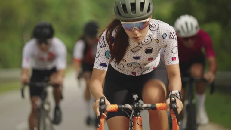 Asian Chinese female cyclist sprinting leading in cycling event at rural in the morning