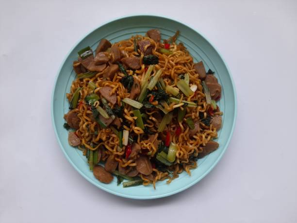 istock fried noodles with mixed mustard greens on a plate top view against a white background. 1471060741