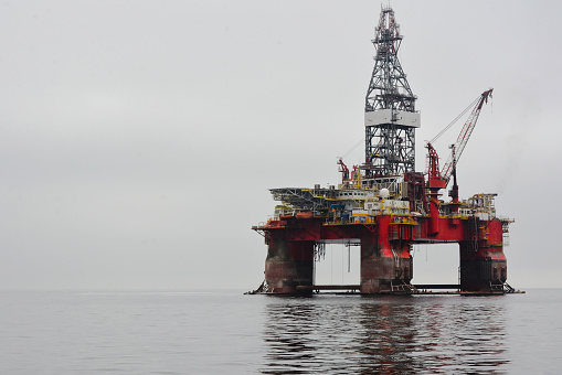 Offshore platform with drilling rig petroleum pump in the ocean at night