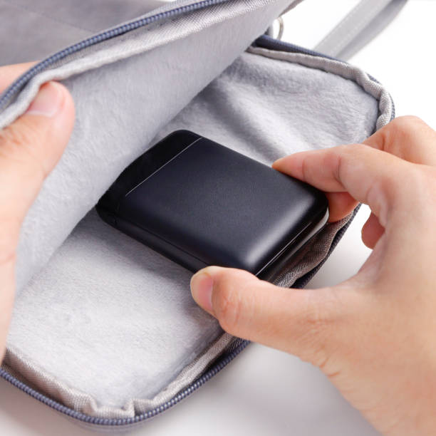 istock Close up man hand put power bank into the bag 1471064262