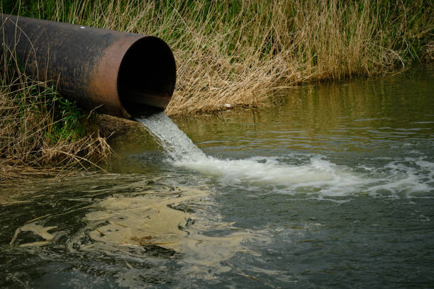 istock Draining sewage from pipe into river, pollution rivers and ecology. 1471071579