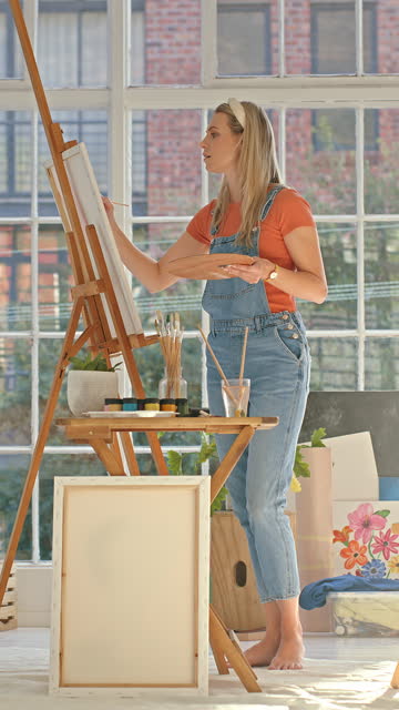 Art, creative and woman painting a picture for a hobby, career or exhibition in a workshop. Talent, creativity and painter with inspiration for an artistic craft, artwork or masterpiece in studio