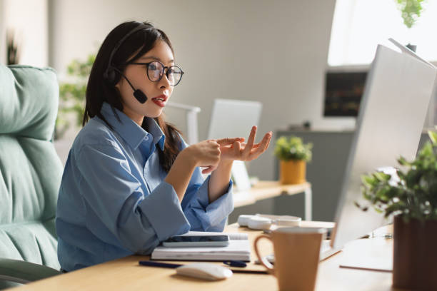 istock Asian woman using laptop wearing headset making video call 1471075637